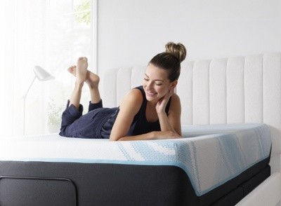 Woman smiling laying on a Tempur Pedic breeze mattress